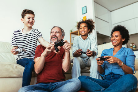 Smiling family enjoying time together at home sitting on sofa in living room and playing video...