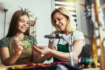 Mother and daughter accessories designers making handmade jewelry in studio workshop. Fashion,...