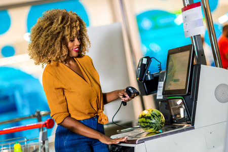 African American Woman buying food at grocery store or supermarket self-checkoutの写真素材