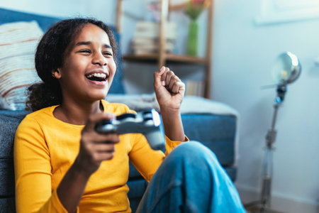 Young African American little girl at home playing video games