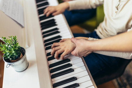 Child practicing on the modern electric piano at home. Music lesson. Close-up.の写真素材