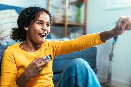 Young African American little girl at home playing video gamesの写真素材