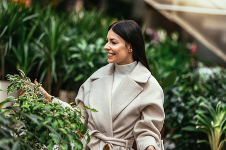 Young woman buying flowers at a garden centerの写真素材