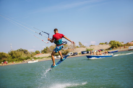 Professional kiter does the difficult trick. A male kiter rides against a beautiful background of...
