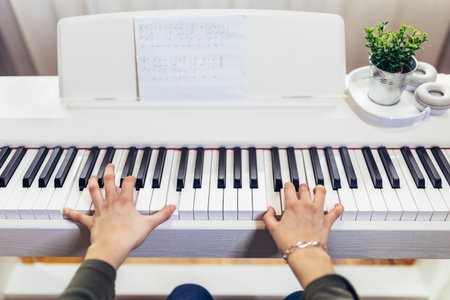 Child practicing on the modern electric piano at home. Music lesson. Close-up.の写真素材