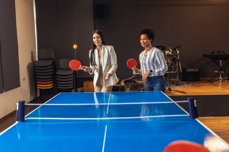 Young people playing table tennis in the office at workの写真素材