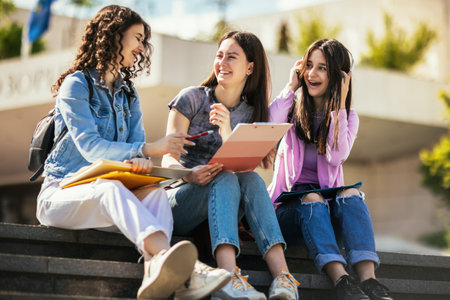 Group of students with notebook studying together outdoors.の写真素材