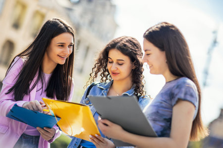 Group of students with notebook studying together outdoors.