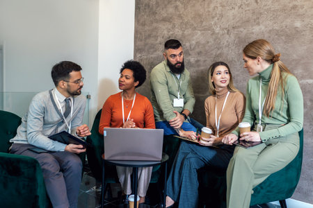 Businesspeople working in an office lobby. Group of  businesspeople sitting together in a co-working spaceの写真素材
