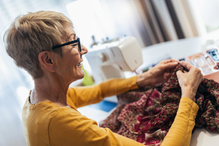 Senior woman sewing at home. Startup small business designer, service.の写真素材