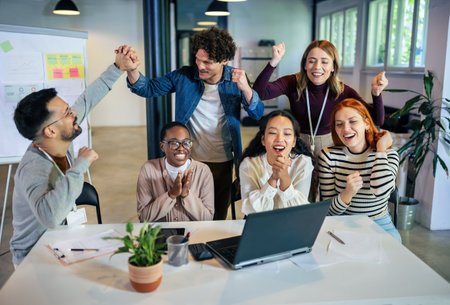 Group of multiethnic business people working together in the office. Group of coworkers cheering in...