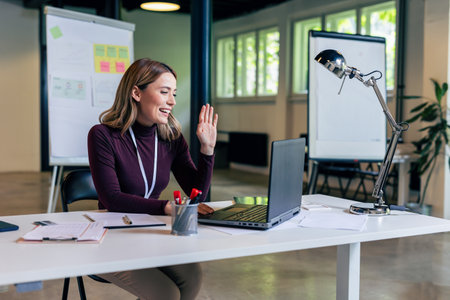 Young businesswoman working on her laptop in the modern office and make video call.