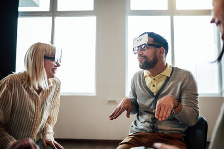 Business team having fun at corporate training, funny teambuilding activity, playing game guess who in the office.の写真素材