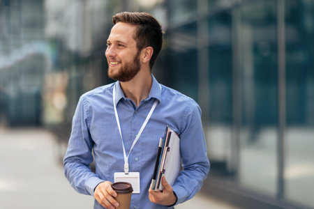 Younge ginger businessman working outside on his tablet while drinking coffee