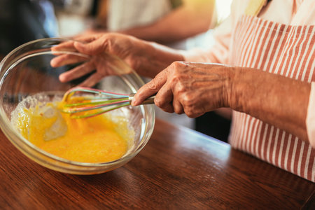 Group of senior friends at dinner party at home, cooking.Close up.の写真素材