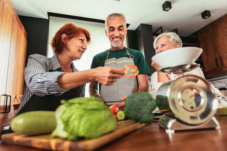 Group of senior friends at dinner party at home, cooking.の写真素材
