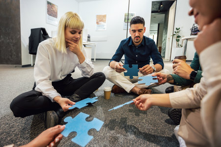 Group of professional people playing puzzle on the floor of the office.Team Building