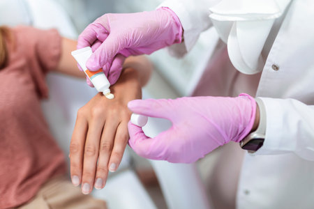 Doctor applying protective cream on patient's handsの写真素材