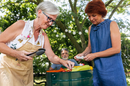 Elderly people are making barbeque, drinking beverages, making memories, and laughing.の写真素材