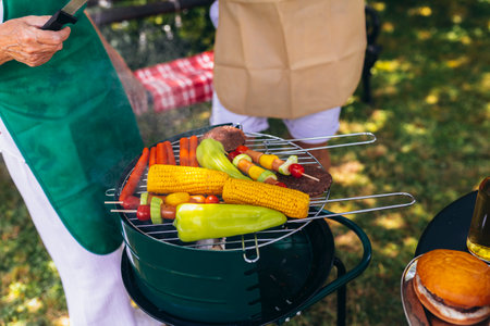 Cropped image of people making grill barbecue outdoors in the backyard.の写真素材