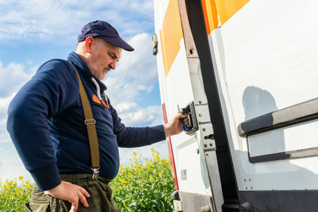 Exhausted and tired truck driver is opening the trunk of his van.