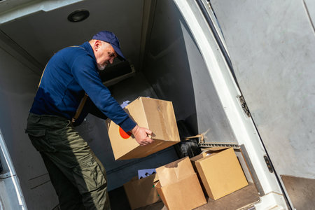 Delivery guy is taking out some boxes that he has been transporting.