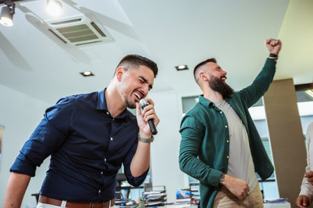 Group of professional people singing karaoke in the modern officeの写真素材