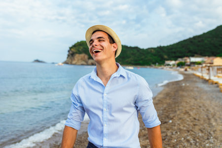 Handsome man walking alone on the beachの写真素材