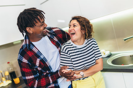 Multiracial couple dancing salsa in the kitchenの写真素材