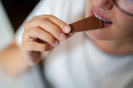 Close-up of woman eating chocolate barの写真素材