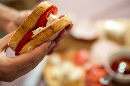 Making a sandwich. Cutting groceries with knife. Spreading sour cream on the toast