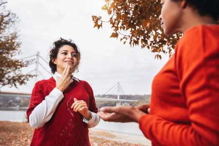 Female friends deaf talking with nonverbal communication outdoor.