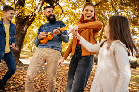 Happy family walking in the park on a sunny fall day. Colorful park.の写真素材