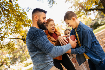 Family playing american football in park. Family and kids, nature concept.の写真素材