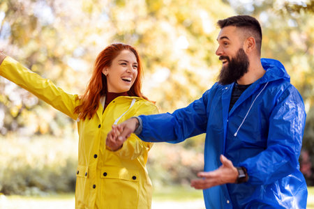 Young couple in love is enjoying in park after rain.の写真素材