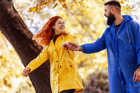 Young couple in love is enjoying in park after rain.の写真素材