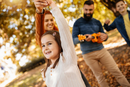 Happy family walking in the park on a sunny fall day. Colorful park.の写真素材