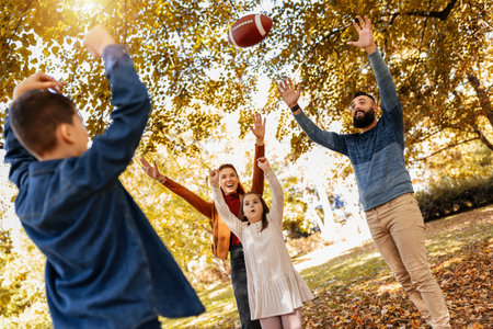 Family playing american football in park. Family and kids, nature concept.の写真素材
