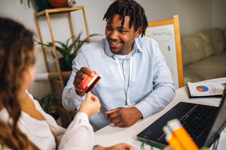 Portrait of young business people ordering something online with card in home office. Couple teamwork startup conceptの写真素材
