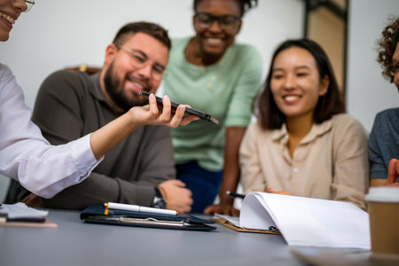 Business people talking on conference call in the office using smart phone.の写真素材