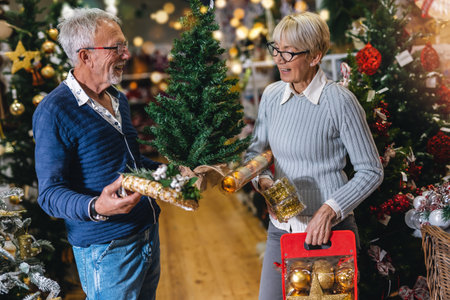 Senior couple at Christmas Market buying decor toys and balls. Concept of Christmas and New Year shopping.
