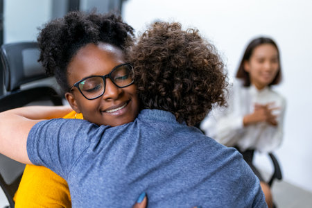 Man and woman hugging at a group therapy session, overcoming problem togetherの写真素材