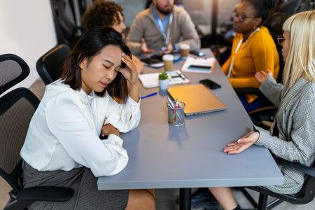 Young asian business woman having headache in the office while having a meetingの写真素材