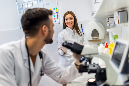 Doctor looking thru microscope while doing research in his labの写真素材