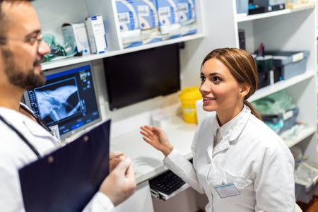 A radiologist looks at an x-ray image in his lab with a nurseの写真素材