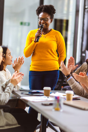 African American business woman talking on the microphone to her colleagues.の写真素材