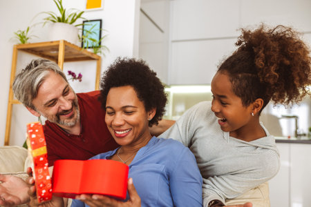 Father and daughter congratulate mother on holiday and give gift boxの写真素材