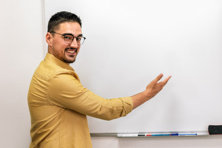 Portrait of a smiling male coach presenting to an audience in the lecture hall.の写真素材