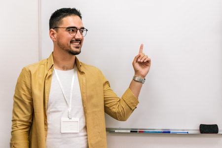 Portrait of a smiling male coach presenting to an audience in the lecture hall.の写真素材