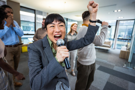 Colleagues having karaoke party in the office